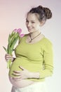 Portrait of lovely smiling pregnant woman with tulips