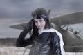 Portrait of lovely young adult woman in retro pilot costume giving military salute Royalty Free Stock Photo