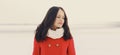 Portrait of lovely young brunette woman wearing red jacket, scarf in the city Royalty Free Stock Photo