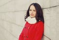 Portrait of lovely young brunette woman wearing red jacket, scarf in the city Royalty Free Stock Photo