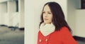 Portrait of lovely young brunette woman wearing red jacket, scarf in the city Royalty Free Stock Photo