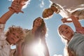 Portrait of lovely young family with two little kids holding hands together and looking down at camera with the blue sky Royalty Free Stock Photo