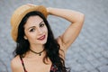 Portrait of lovely young female with dark luxurious hair, appealing eyes, red lips smiling gently while posing at camera wearing s