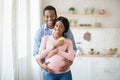 Portrait of loving black husband hugging his pregnant wife at home Royalty Free Stock Photo