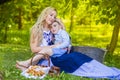 Portrait of Loving Caucasian Mother With Her Little Kid. Posing with Basket Full of Bread Rings Outdoors Royalty Free Stock Photo