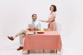 Portrait of loving couple, man reading newspaper, woman serving table with coffee and pie, having breakfast  on Royalty Free Stock Photo