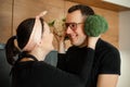 Portrait of loving family cooking together in kitchen. Wife holding green cauliflower at husbands head instead of ears. Royalty Free Stock Photo