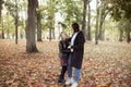 Portrait of loving family of young woman mother and teenage girl daughter walking among trees in forest park in autumn. Royalty Free Stock Photo