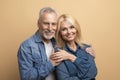 Portrait of loving happy senior couple spouses posing on beige Royalty Free Stock Photo