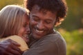 Portrait Of Loving Mature Couple Hugging Outdoors Against Flaring Evening Sun Royalty Free Stock Photo