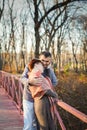 Portrait of loving middle-aged couple in warm clothes hugging in the autumn park at sunset in selective focus Royalty Free Stock Photo