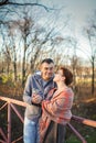 Portrait of loving middle-aged couple in warm clothes hugging in the autumn park at sunset in selective focus Royalty Free Stock Photo