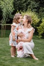 Portrait of loving mother and two adorable kids. little girl and newborn baby girl with mom outdoors on summer day. Happy family Royalty Free Stock Photo