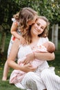 Portrait of loving mother and two adorable kids. little girl and newborn baby girl with mom outdoors on summer day. Happy family Royalty Free Stock Photo