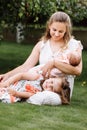 Portrait of loving mother and two adorable kids. little girl and newborn baby girl with mom outdoors on summer day. Happy family Royalty Free Stock Photo