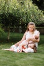 Portrait of loving mother and two adorable kids. little girl and newborn baby girl with mom outdoors on summer day. Happy family Royalty Free Stock Photo