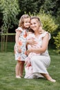 Portrait of loving mother and two adorable kids. little girl and newborn baby girl with mom outdoors on summer day. Happy family Royalty Free Stock Photo