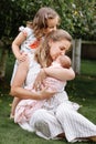 Portrait of loving mother and two adorable kids. little girl and newborn baby girl with mom outdoors on summer day. Happy family Royalty Free Stock Photo