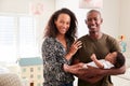 Portrait Of Loving Parents Standing In Nursery Cuddling Baby Son At Home Royalty Free Stock Photo