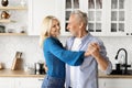 Portrait Of Loving Senior Couple Dancing Together In Kitchen Interior Royalty Free Stock Photo