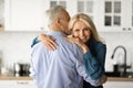 Portrait Of Loving Senior Couple Embracing In Kitchen Interior Royalty Free Stock Photo