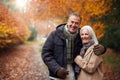 Portrait Of Loving Senior Couple Hugging As They Walk Along Autumn Woodland Path Through Trees Royalty Free Stock Photo