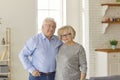 Portrait of a loving senior couple hugging each other standing in the kitchen at home. Royalty Free Stock Photo