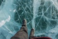 Portrait of man in black long pants and boot shoes on frozen Lake Khovsgol in Mongolia