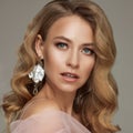 Portrait of luxury blonde woman with perfect makeup posing holding pink rose Royalty Free Stock Photo