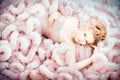 Portrait of lying model in fashion beige pink cloud dress. Fashion