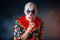 Portrait of mad bloody clown shows the quiet sign