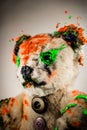 Portrait of magic teddy bear painted by green and orange