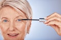 Portrait, makeup and senior woman mascara for eye, skincare or wellness for natural beauty against blue studio Royalty Free Stock Photo