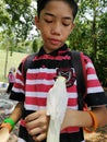 Portrait of a malay boy with a parrot on his hand