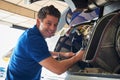 Portrait Of Male Aero Engineer Working On Helicopter In Hangar