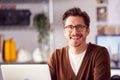 Portrait Of Male Architect Sitting At Desk In Office Working On Laptop