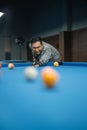 portrait of the male billiard player smiling while poking the ball Royalty Free Stock Photo