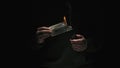 Portrait of male in black clothes isolated on black background in low light. Man holding hundred dollar banknote lights Royalty Free Stock Photo