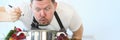 Portrait of male chef preparing and tasting hot food in vegetable soup spoon Royalty Free Stock Photo