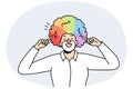 Portrait of male clown with rainbow hairstyle.