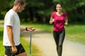 Portrait of male coach timing runner outdoors