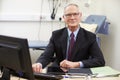 Portrait Of Male Consultant Working At Desk