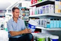 Portrait of male customer selecting paint can in housewares department