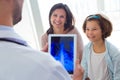 Male doctor consulting the chest radiography of the girl in the office.