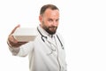 Portrait of male doctor handing lunch box