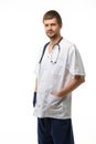 Portrait of a male doctor, hands stuck in pockets, a phonendoscope hangs around his neck, isolated on white background Royalty Free Stock Photo