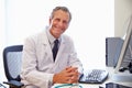 Portrait Of Male Doctor In Office Working At Computer Royalty Free Stock Photo