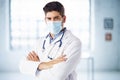 Portrait of male doctor wearing face mask while standing in the hospital foyer Royalty Free Stock Photo