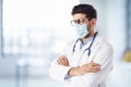 Portrait of male doctor wearing face mask while standing in the hospital foyer Royalty Free Stock Photo