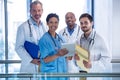 Portrait of male doctors and nurse using digital tablet in corridor Royalty Free Stock Photo